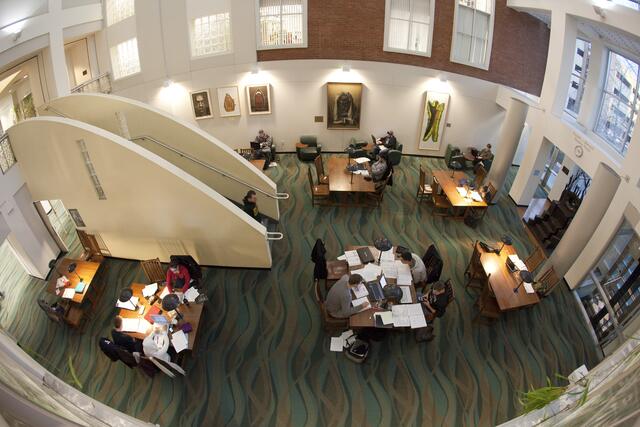 An overhead view of the Atrium at Alexander Library with groups of students studying at tables
