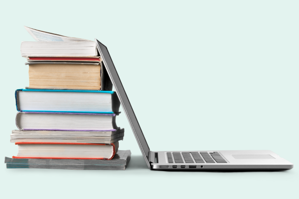 a stack of books and a laptop