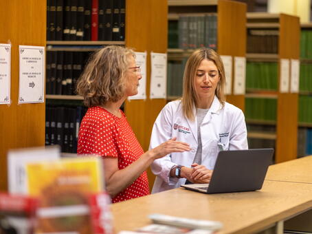 A librarian assists a student with her computer at RWJ Library