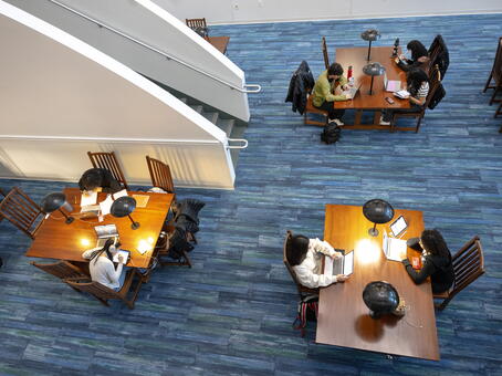 students working at tables in AlexAnder Library's lower atrium study area