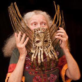 Photo of Suzanne Benton, holding one of her art pieces up to her face