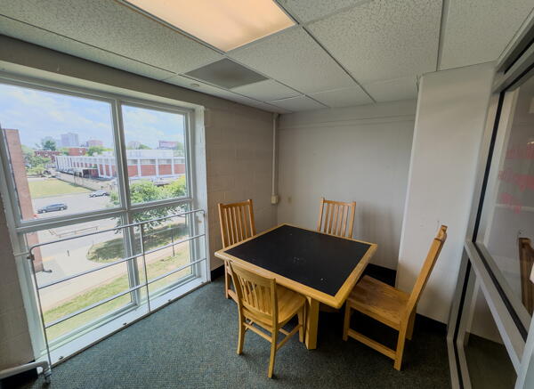 Interior of group study room with square table, four chairs, and a large window