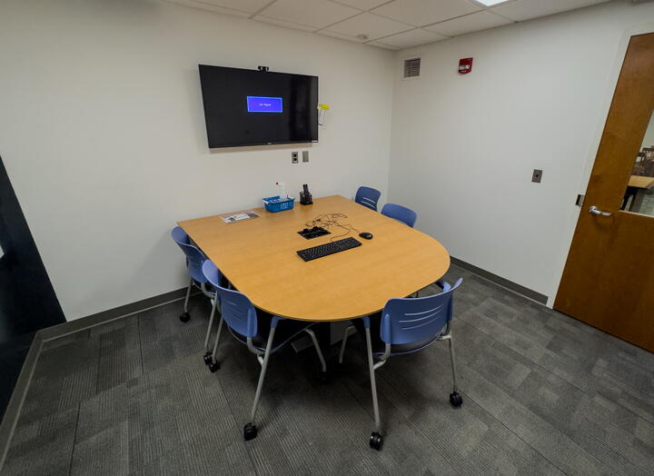 Interior of group study room with table, chairs and a wall-mounted display