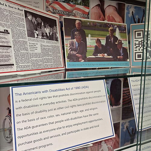 Detail of the ADA Anniversary Exhibit: Picture includes images of President Bush signing the bill, a clipping form a newspaper, and a textual card about the ADA.