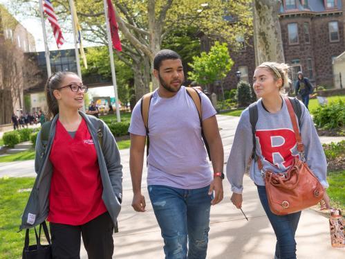 3 students walking across Camden campus in Spring