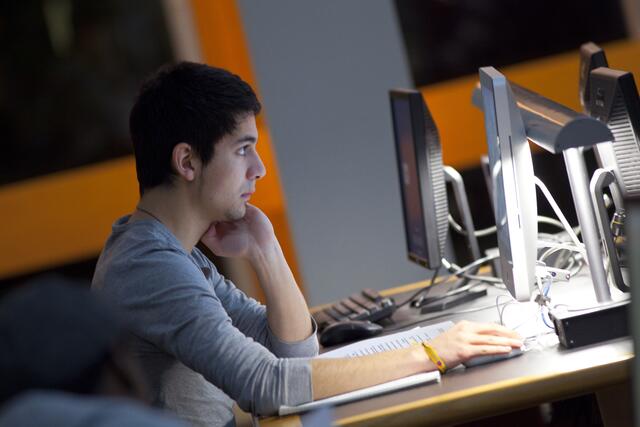 A student uses a computer in Douglass Library at night