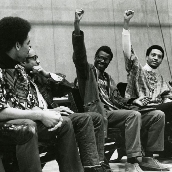 Two African American men raising their fists and smiling
