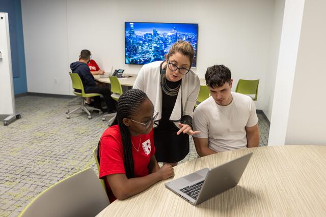 Photo of a Dana staff member helping students in the study room space