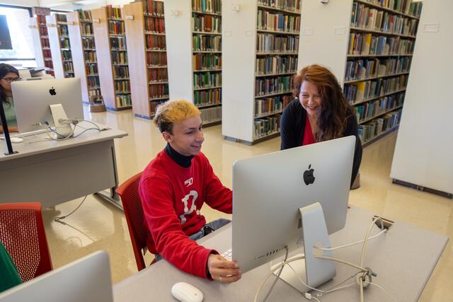 A staff member of the LSM assisting a student on one of the Mac computer stations