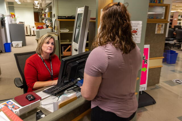 Robeson faculty member aiding a student from her help desk