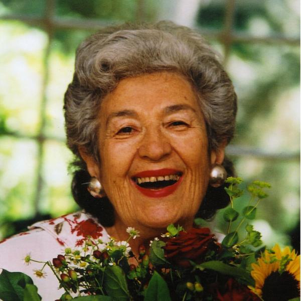 Photo of Miriam Schapiro smiling with a green background 