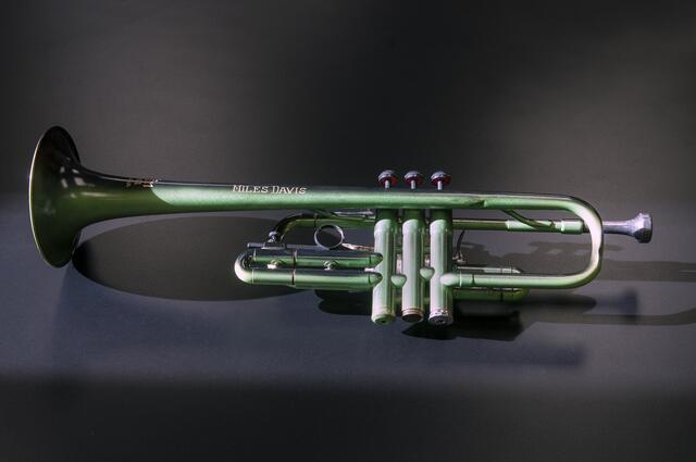 A green trumpet owned by Miles Davis inscribed with his name