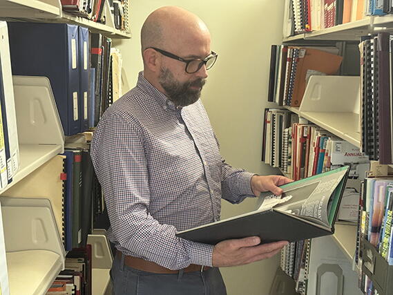 Librarian Bart Everts looking at a book in Robeson Library Special Collections