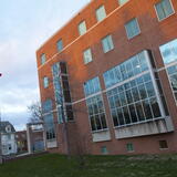 An exterior view of Alexander Library showing flags flying in the wind