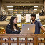 Students looking at a laptop in the Math and physics library