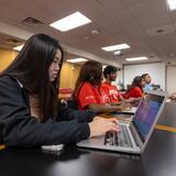 Students in the classroom in the Carr library with laptops listening to lecture
