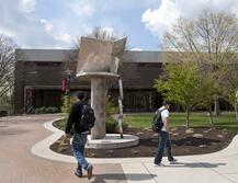 Exterior of Carr Library with students walking past book sculpture