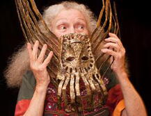 Photo of Suzanne Benton, holding one of her art pieces up to her face