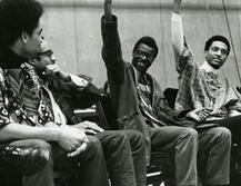 Two African American men raising their fists and smiling