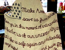art: standing woman with blanket with embroidery on it..from the back