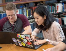 students in library working on laptops